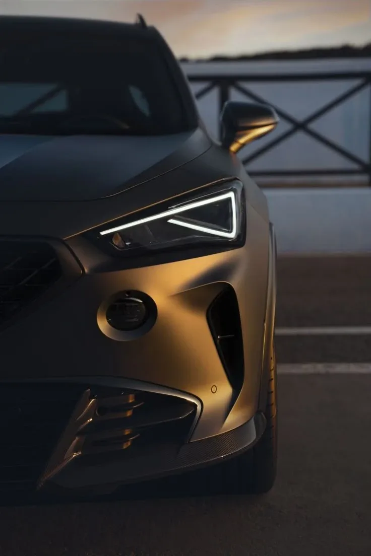 Faro LED con firma luminosa triangular de un SUV deportivo al atardecer