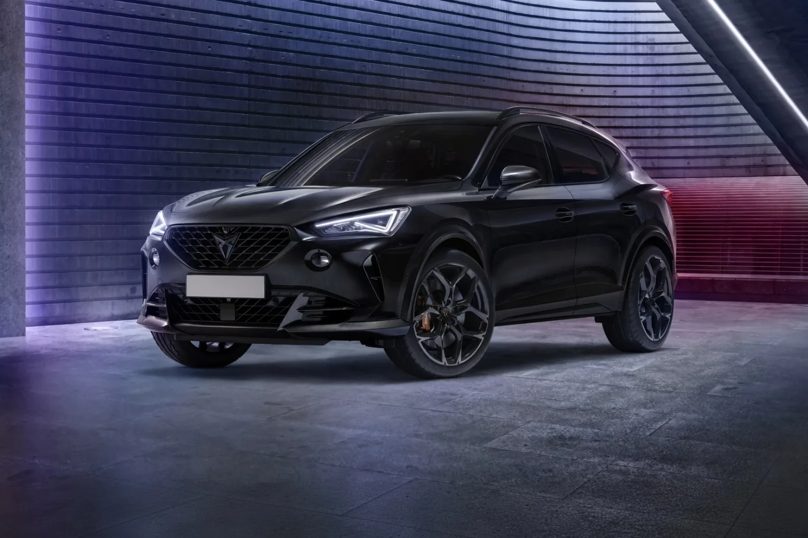 SUV deportivo negro con llantas oscuras en un garaje con luces de neón, vista frontal tres cuartos