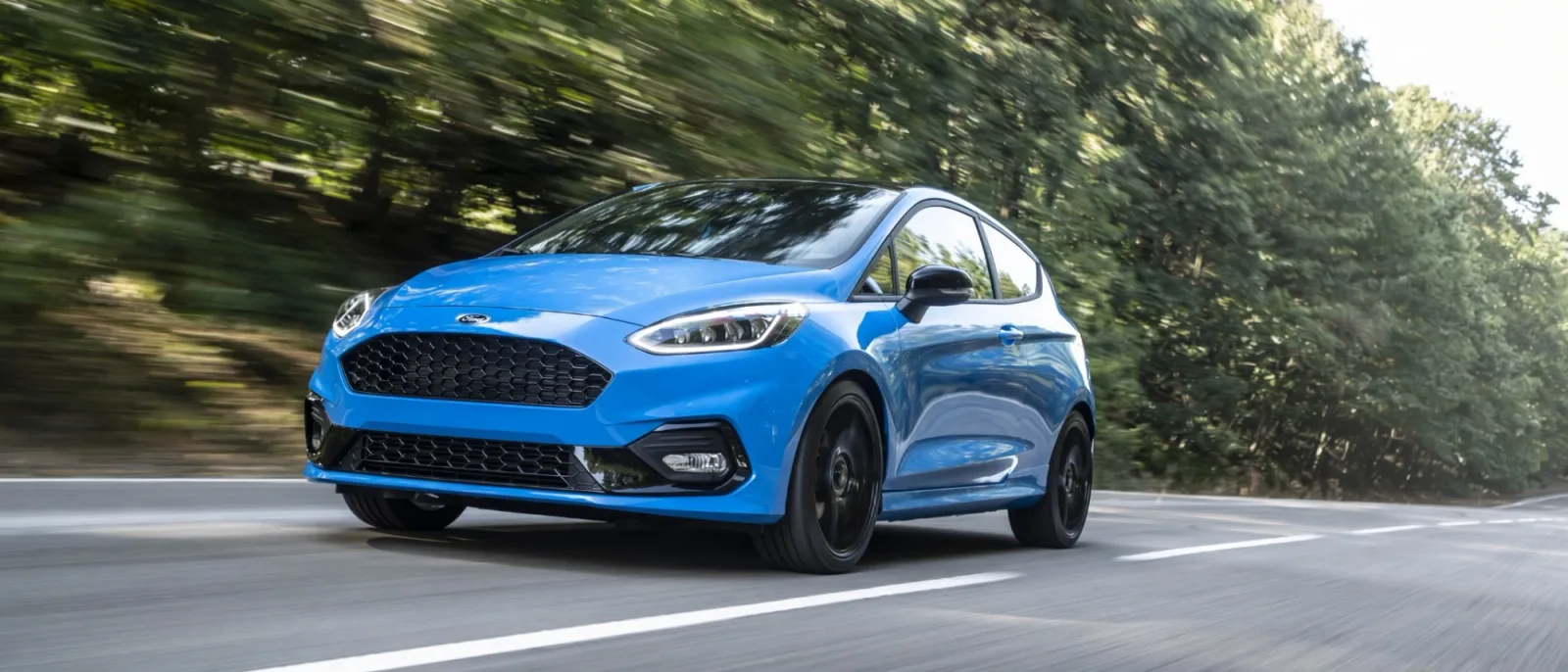 Ford Fiesta ST azul en movimiento por carretera, vista frontal