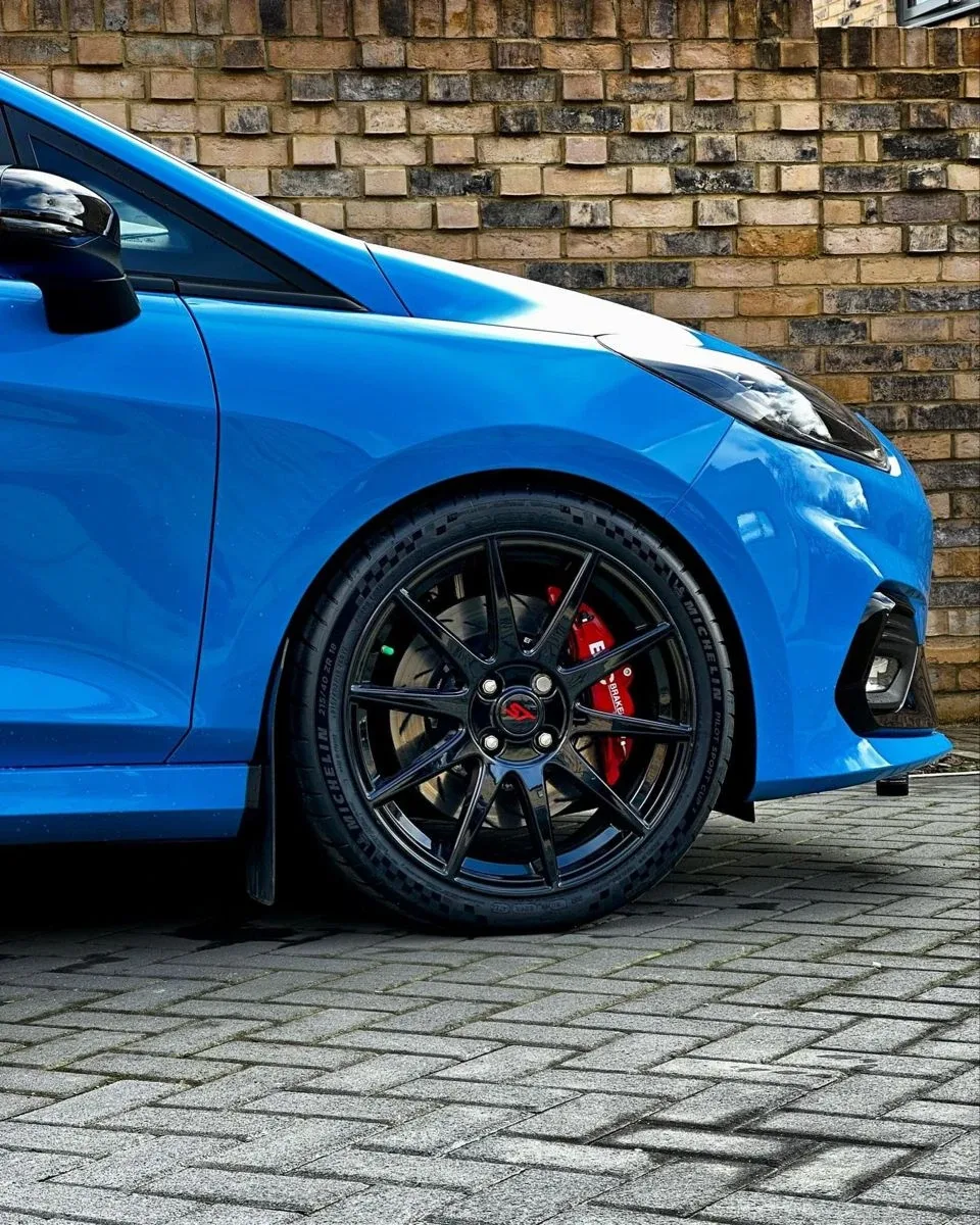 Llanta negra y pinza de freno roja de un Ford Fiesta ST azul