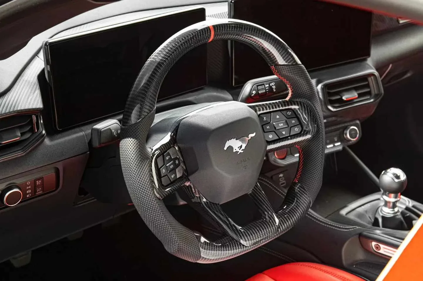 Interior del Ford Mustang S650 con volante de carbono, pantallas digitales y palanca del cambio manual de seis marchas