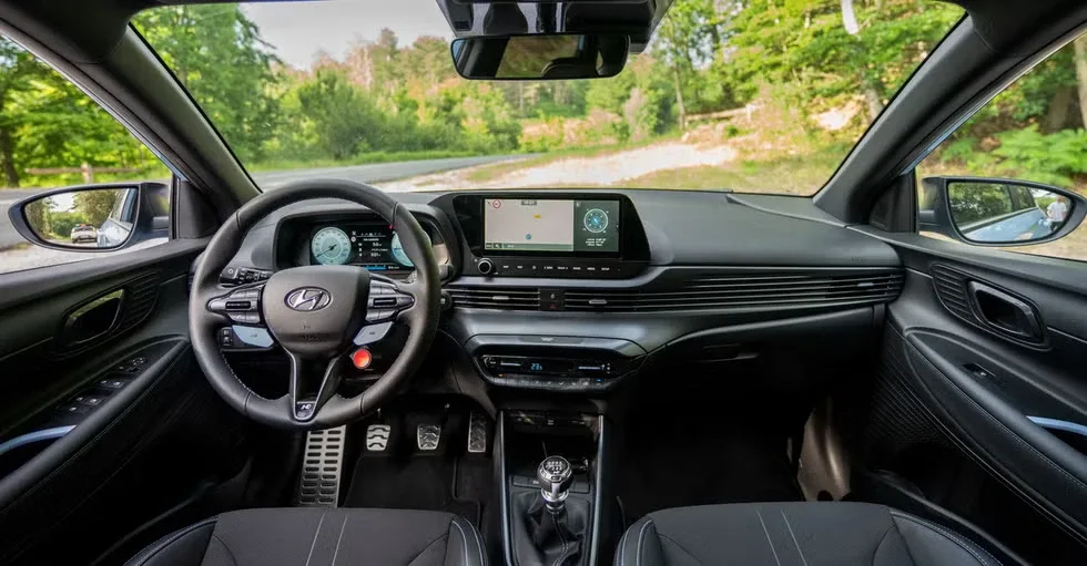 Interior del Hyundai i20 N con volante, pantalla y palanca de cambio manual