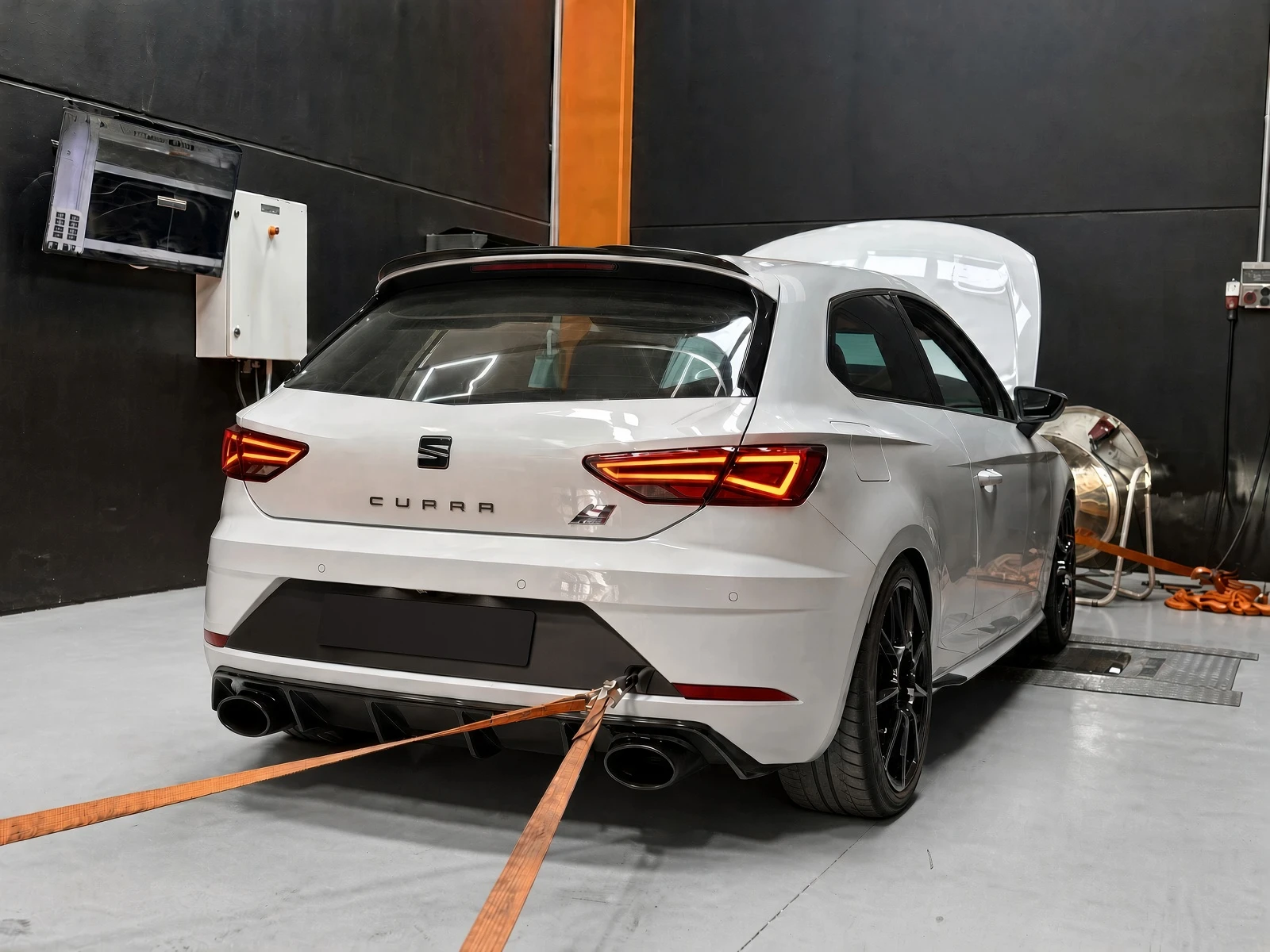 SEAT León Cupra blanco de tres puertas sobre un banco de rodillos con el capó abierto durante una medición de potencia