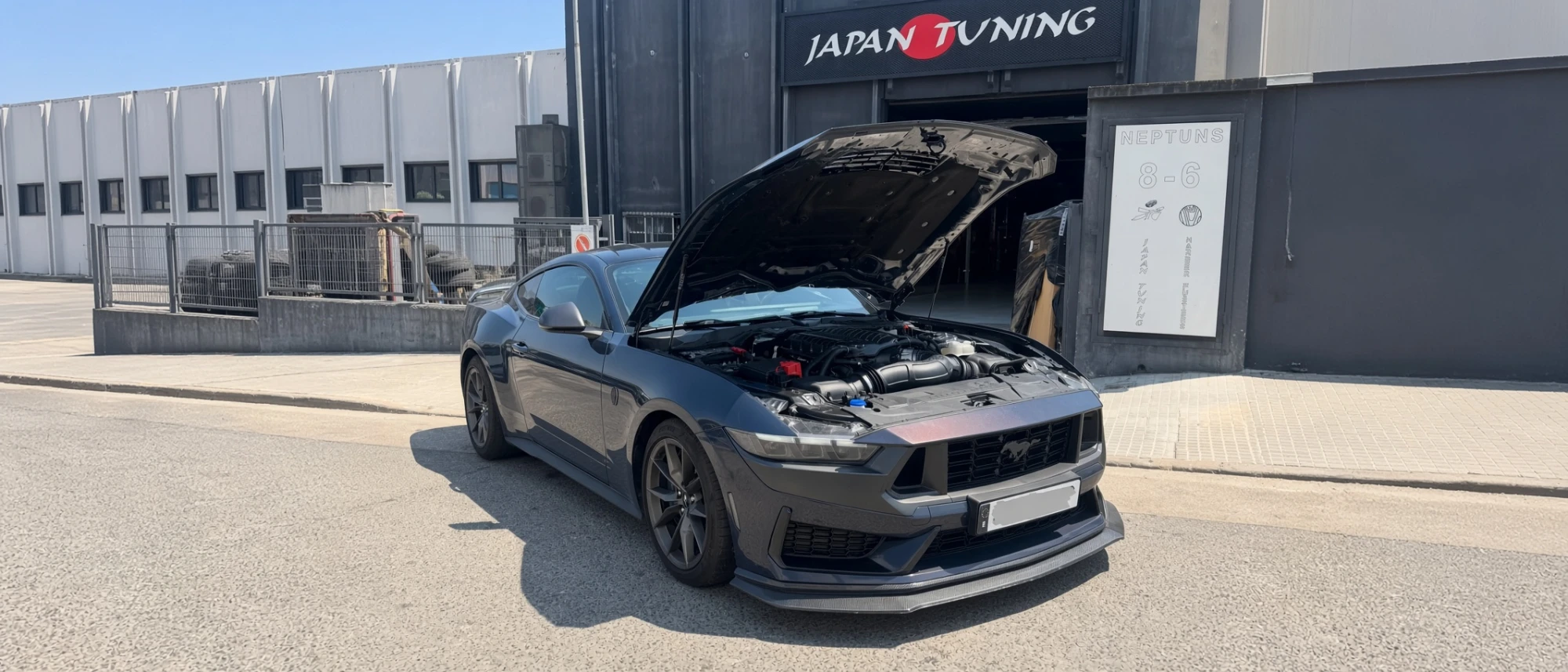 Ford Mustang S650 Dark Horse Whipple con el capó abierto frente al taller Japan Tuning